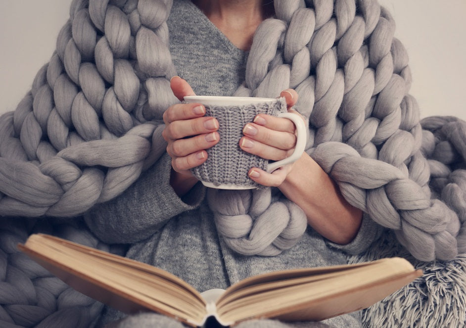 Woman in blanket holding mug