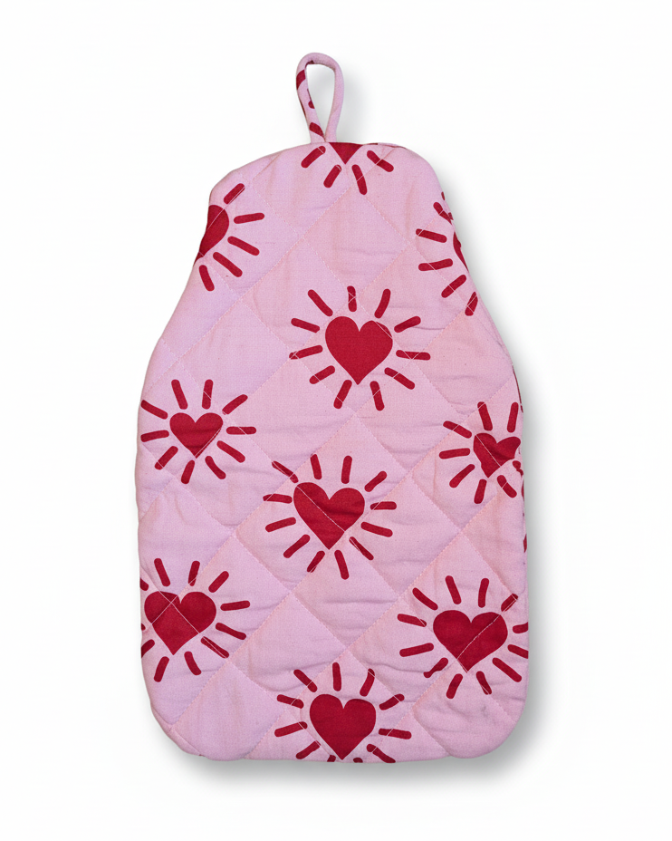 Red heart and sun patterns on a pink quilted hot water bottle cover