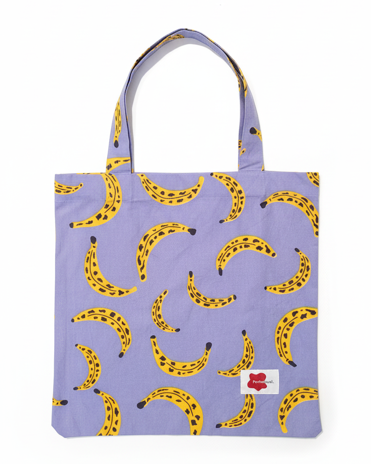 Tote bag with ripe spotty banana pattern on a purple background